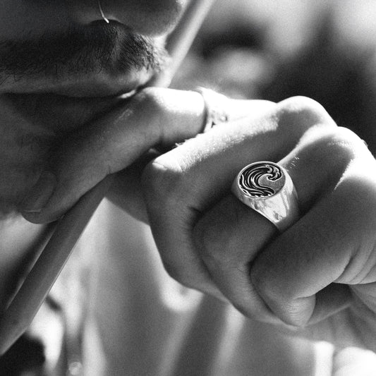 Solaque Ocean Drift handmade sterling silver wave design ring jewellery on hand, holding a pen