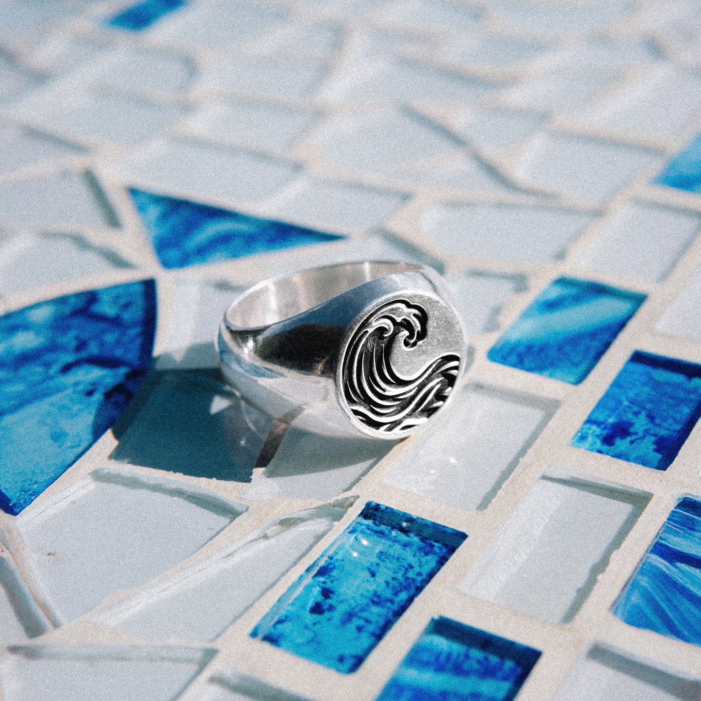 Solaque Ocean Drift handmade sterling silver wave design ring jewellery on a mosaic tile surface