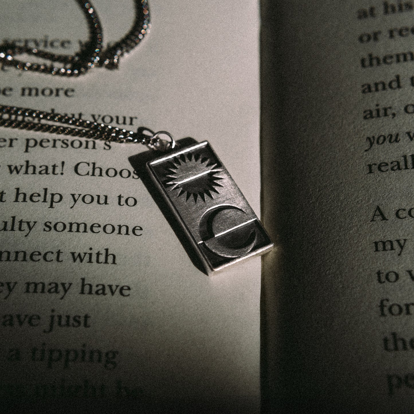 Solaque Solar Mirage handmade sterling silver pendant jewellery on book