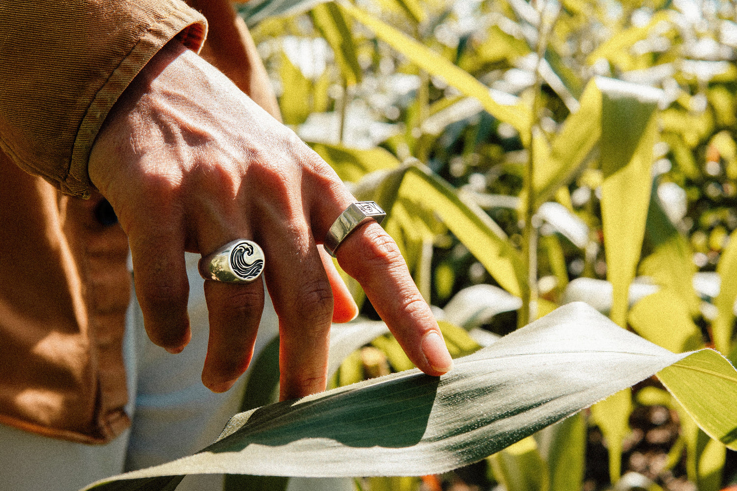 Solaque handmade sterling silver ring jewellery on hand touching a leaf in a natural setting