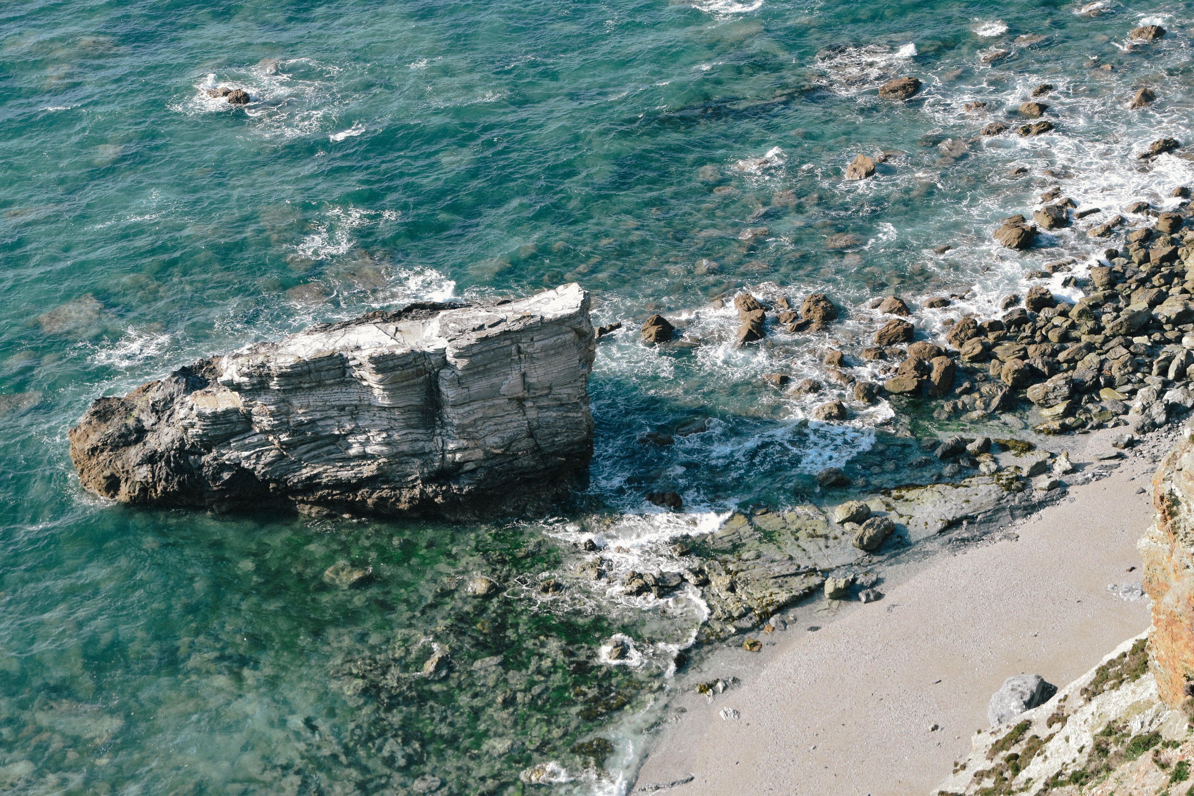 Looking down at the ocean sea, rocks and a beach