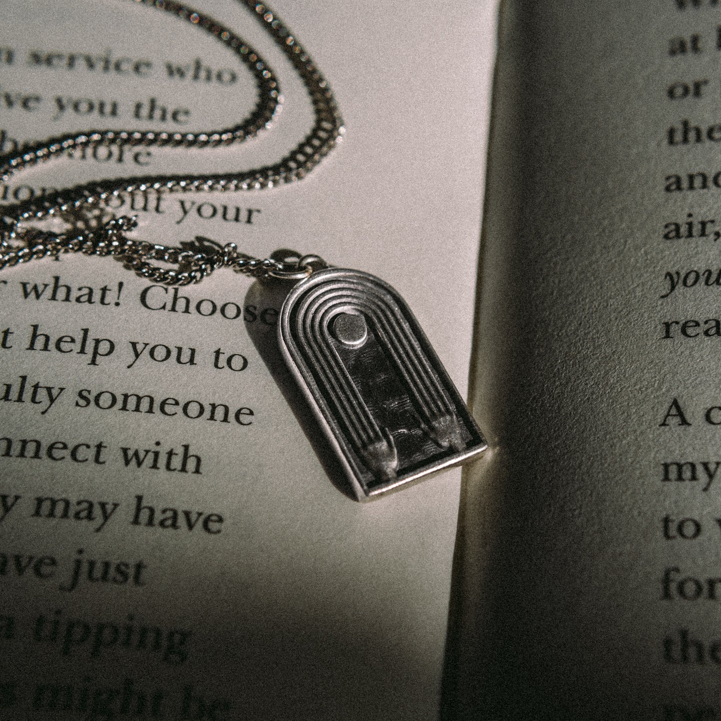 Solaque Crescent Hold handmade sterling silver pendant jewellery on book