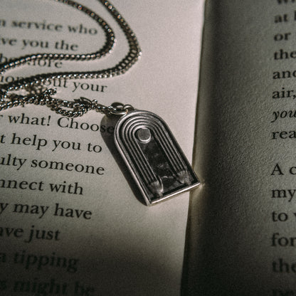 Solaque Crescent Hold handmade sterling silver pendant jewellery on book