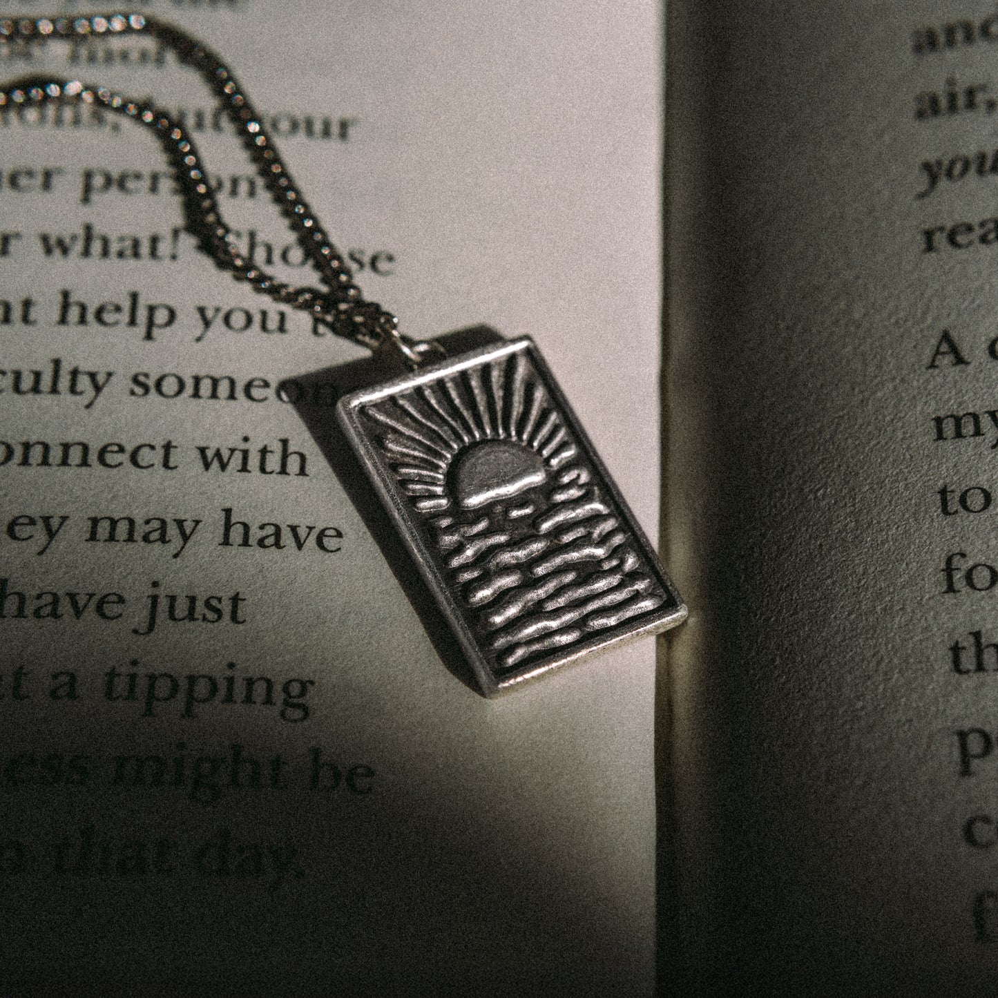 Solaque Echoes of Dusk handmade sterling silver pendant jewellery on book