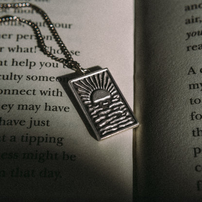 Solaque Echoes of Dusk handmade sterling silver pendant jewellery on book