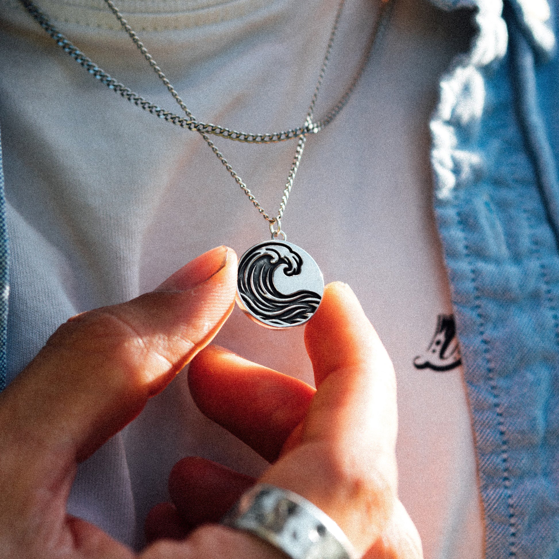 Solaque Ocean Drift handmade sterling silver wave design pendant jewellery held between fingers