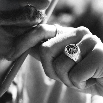 Solaque Ocean Drift handmade sterling silver wave design ring jewellery on hand, holding a pen