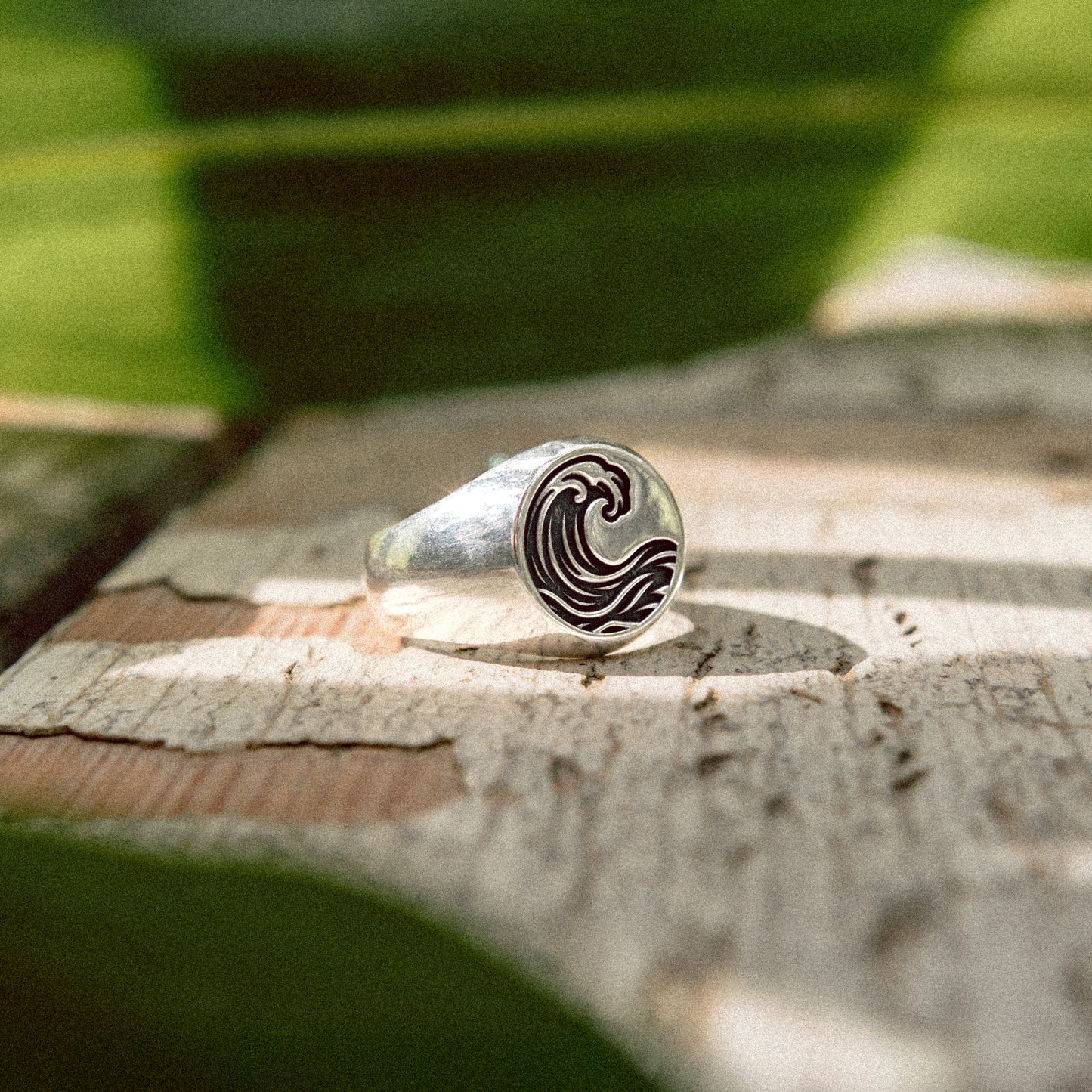 Solaque Ocean Drift handmade sterling silver wave design ring jewellery on a rustic wooden surface