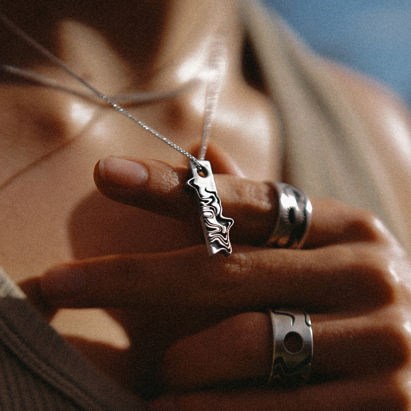 Solaque Tidal Motion handmade sterling silver pendant jewellery holding against hand