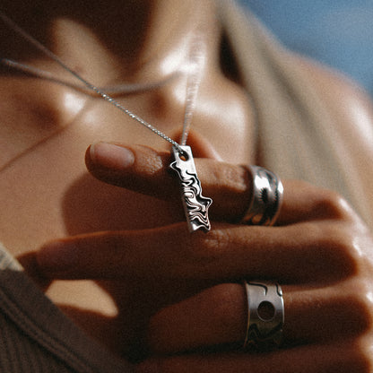 Solaque Tidal Motion handmade sterling silver pendant jewellery holding against hand