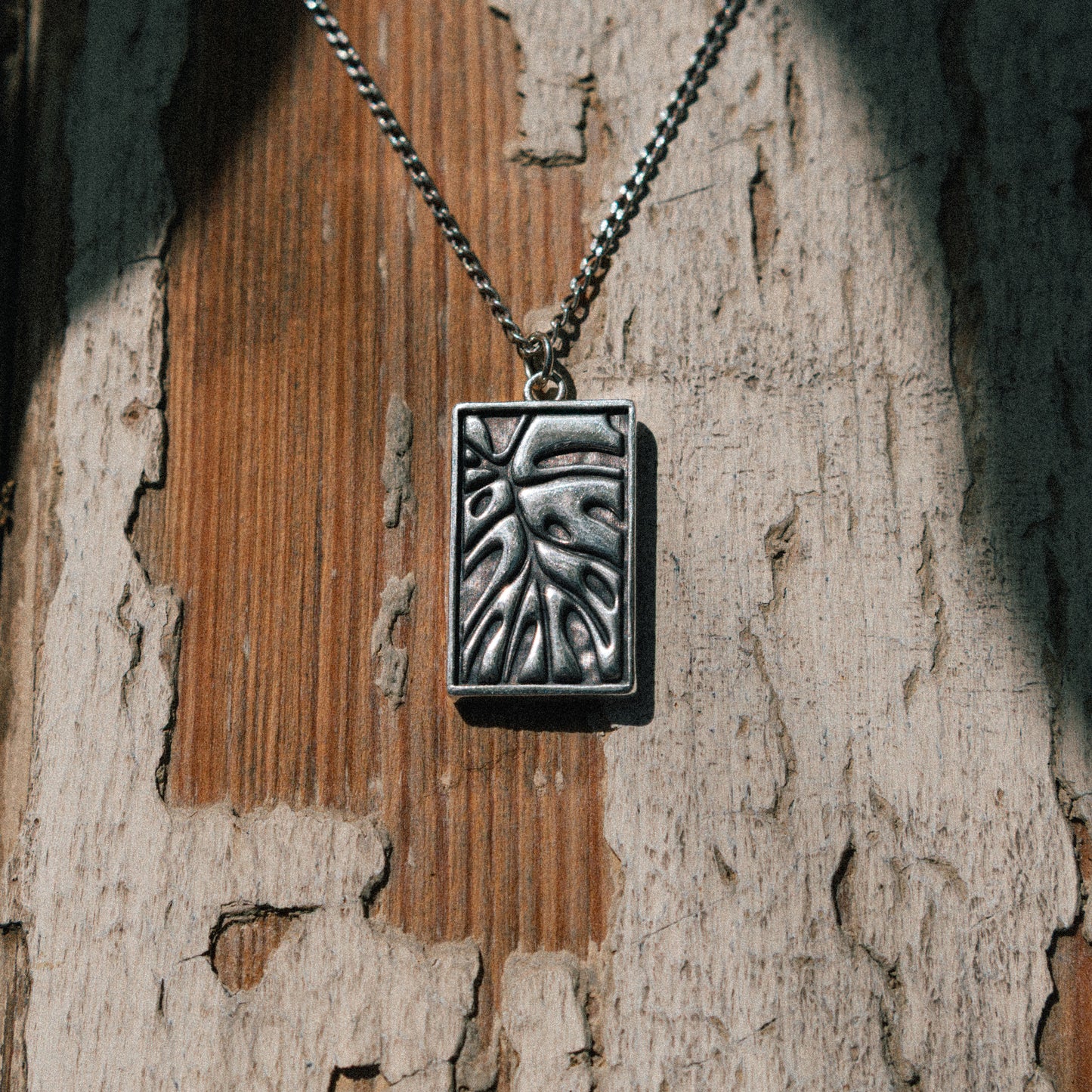 Solaque Veins of Monstera handmade sterling silver leaf design pendant jewellery on a rustic wooden surface