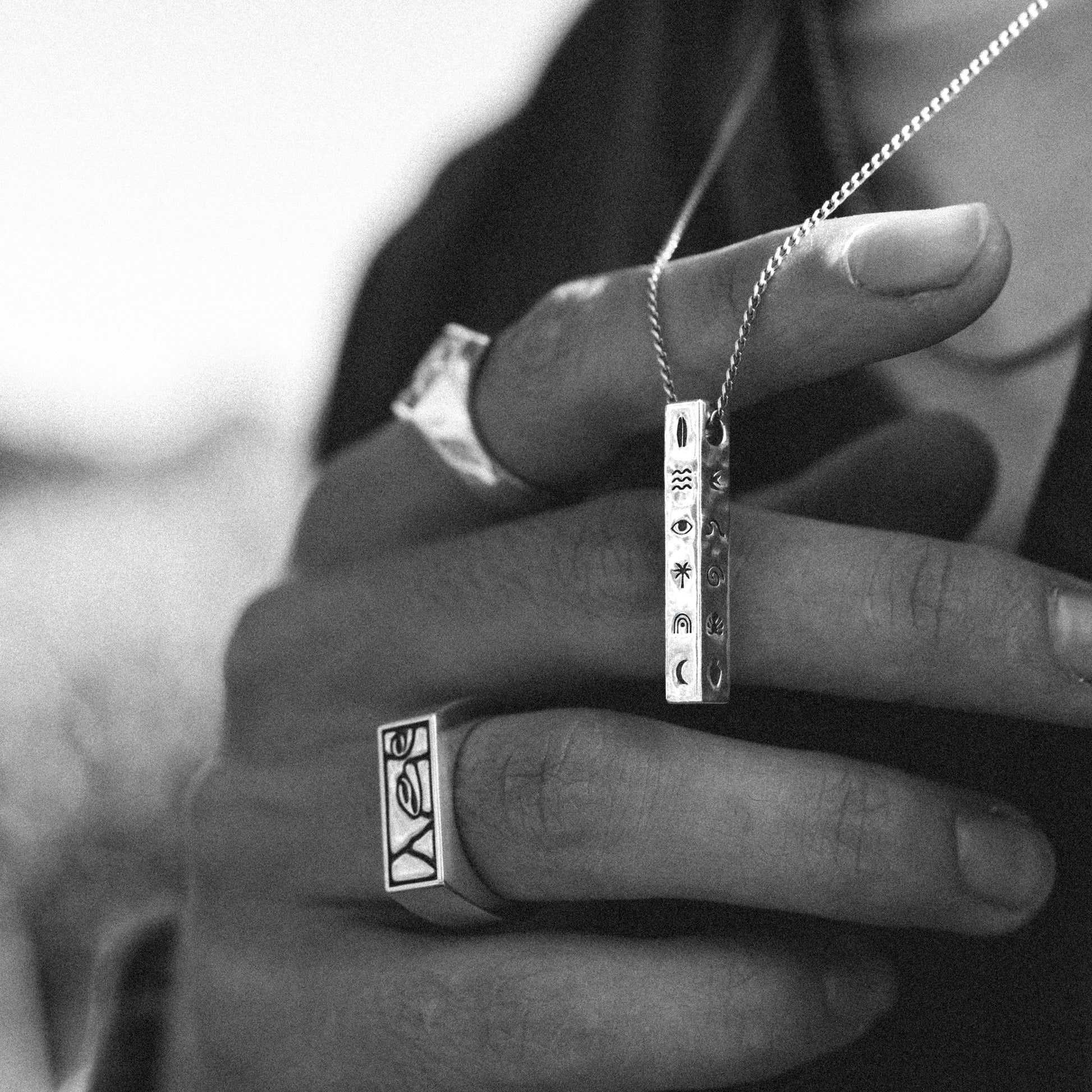 Solaque Wanderer's Script handmade sterling silver icon design pendant jewellery held against fingers