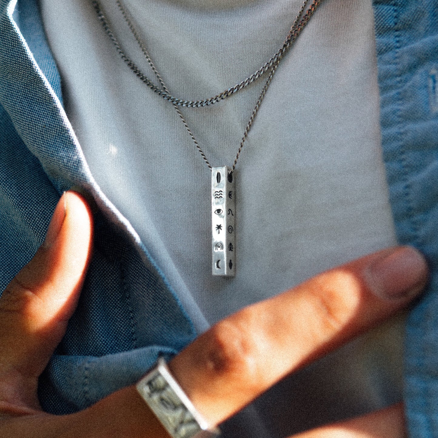 Solaque Wanderer's Script handmade sterling silver icon design pendant jewellery worn by a person