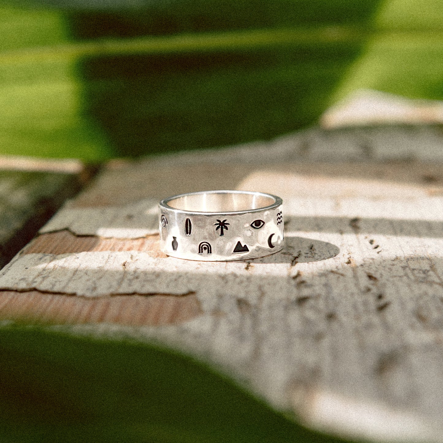 Solaque Wanderer's Script handmade sterling silver icon design ring jewellery   on a rustic wooden surface