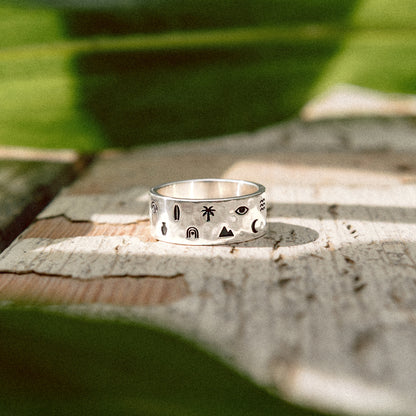 Solaque Wanderer's Script handmade sterling silver icon design ring jewellery   on a rustic wooden surface